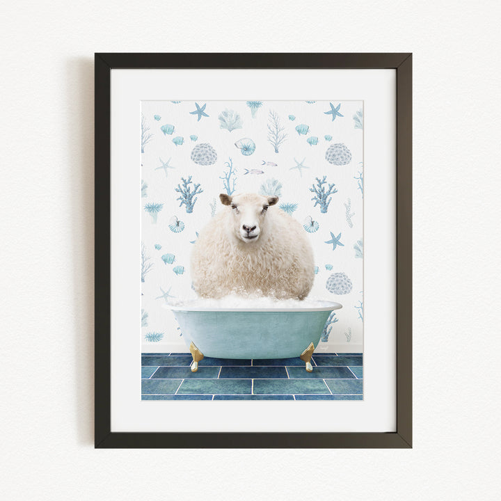 A framed image depicting a fluffy white sheep sitting in a blue bathtub filled with bubbles, surrounded by a pattern of blue and white seashells and starfish.