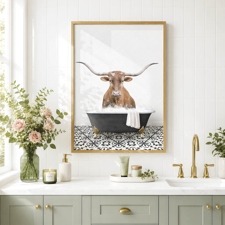 a framed picture of a bull with long horns sitting in a bathtub, surrounded by flowers and candles, with a white tiled wall and a sink in the background.
