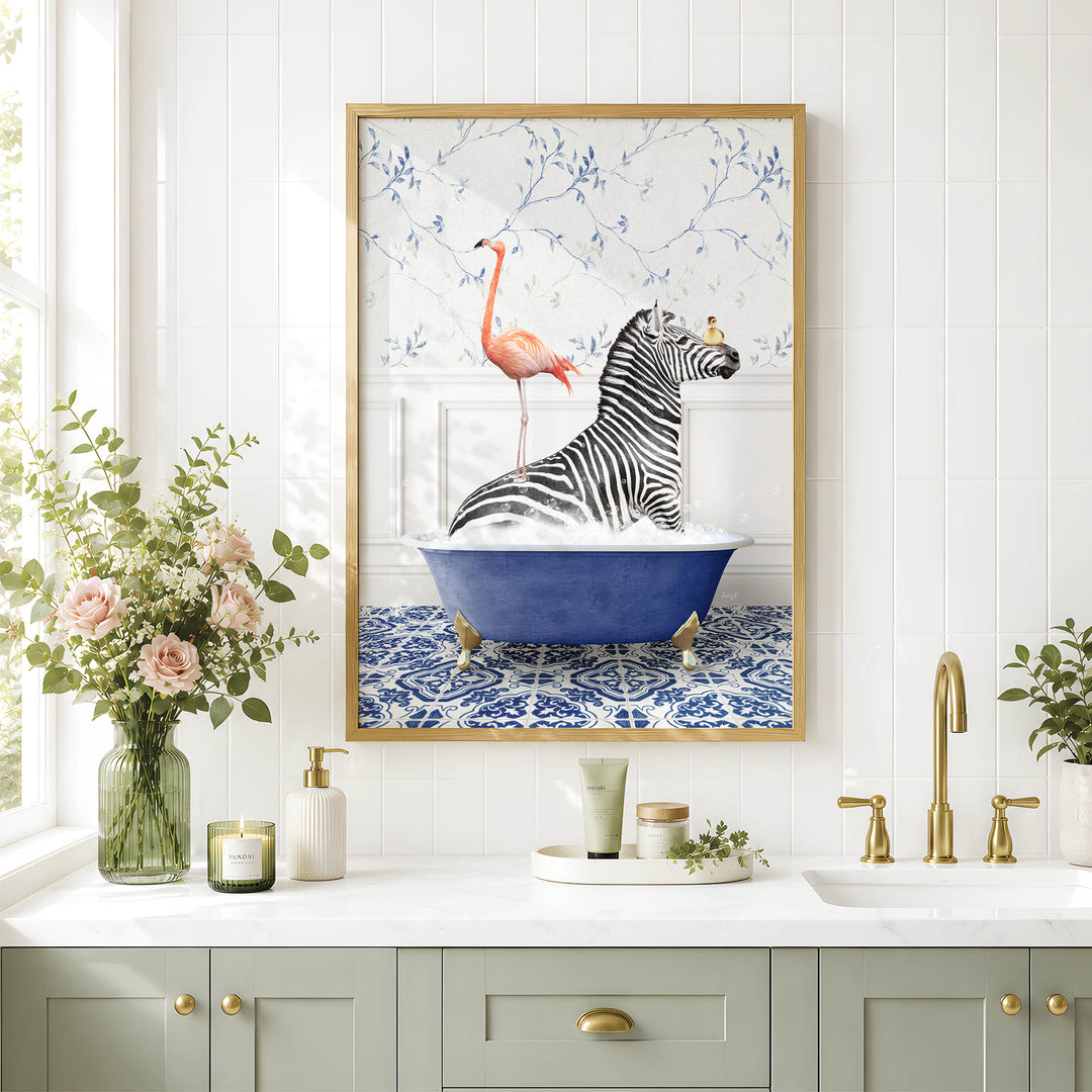 a bathroom scene with a framed painting of a zebra sitting in a blue bathtub, accompanied by a pink flamingo. The painting is hung on a white wall above a white countertop with various bathroom accessories, such as a vase with flowers, a soap dispenser, and a candle.