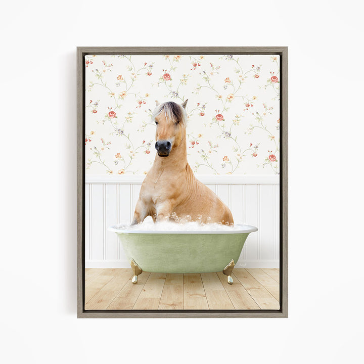 A light brown horse is sitting in a green bathtub filled with water, surrounded by a floral wallpaper.