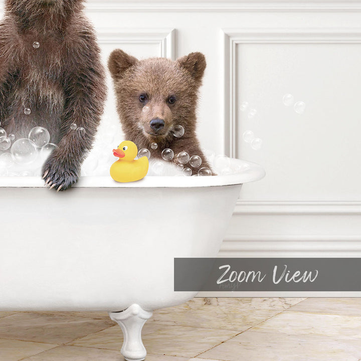 A baby bear sitting in a bathtub, surrounded by bubbles, with a rubber duck nearby.