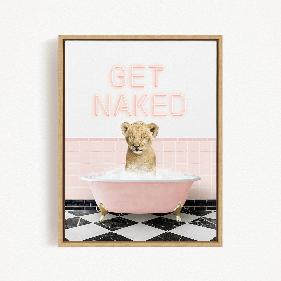 A framed image depicting a young lion cub sitting in a pink bathtub filled with bubbles, with the text "GET NAKED" displayed above it.