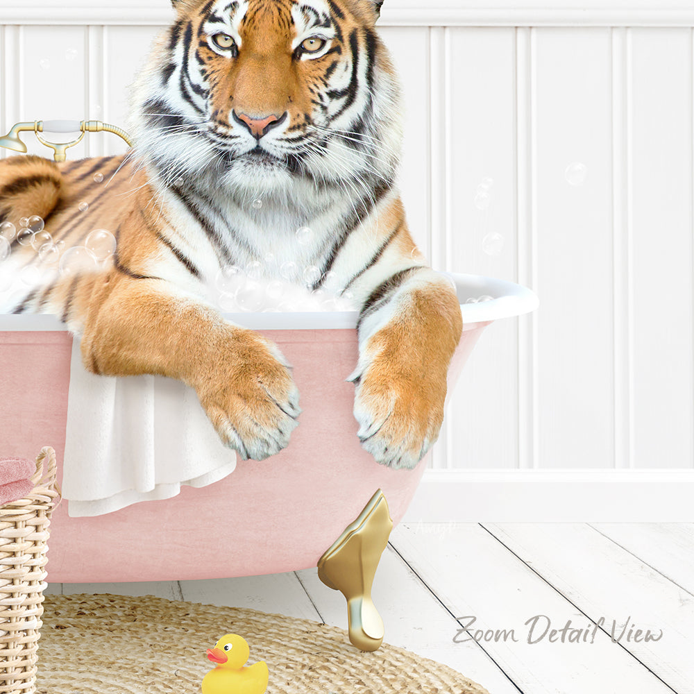A tiger is sitting in a pink bathtub filled with water, surrounded by a yellow rubber duck and a white basket.