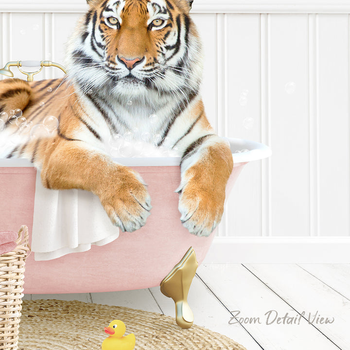 A tiger is sitting in a pink bathtub filled with water, surrounded by a yellow rubber duck and a white basket.