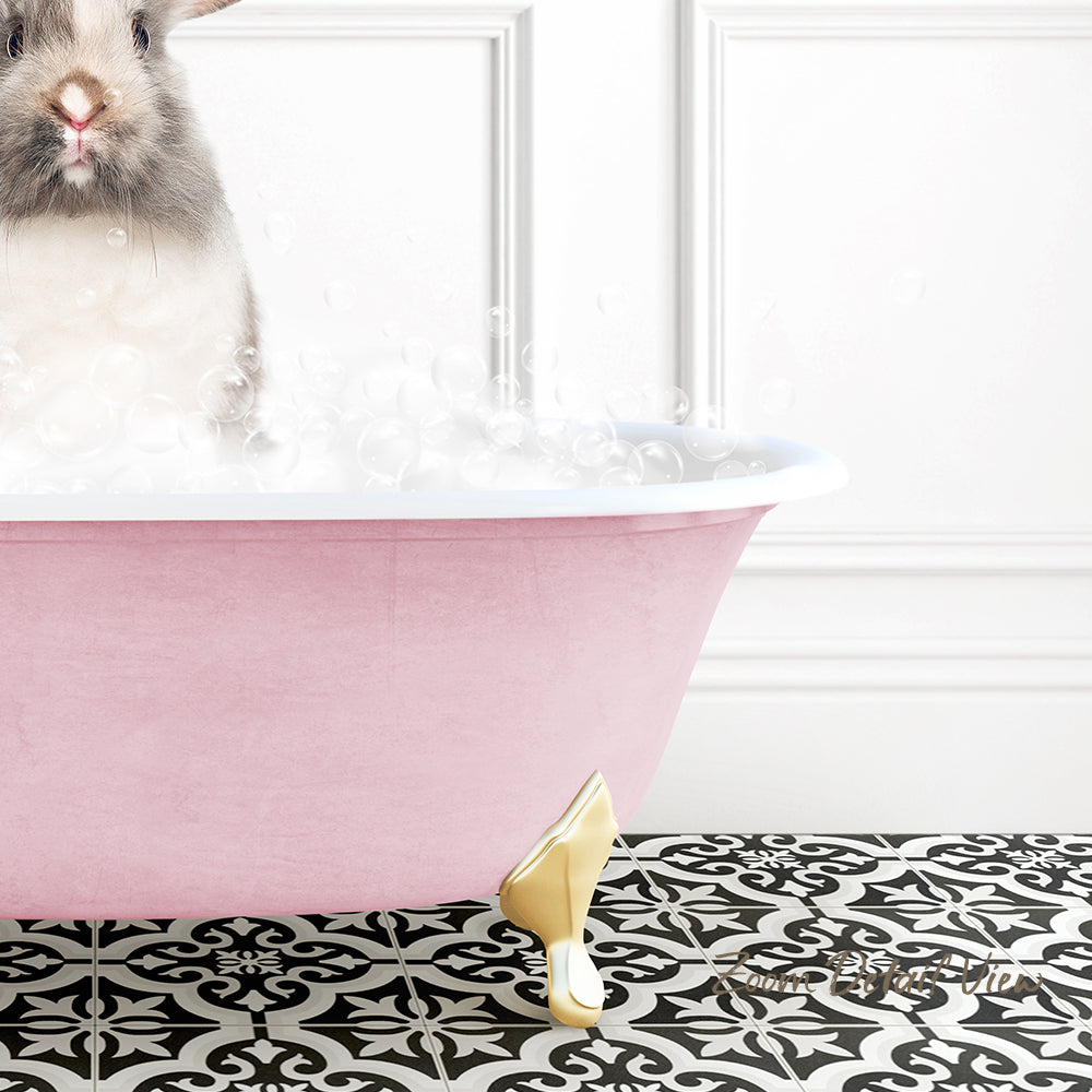 A small, fluffy rabbit is sitting in a pink bathtub filled with bubbles, creating a whimsical and adorable scene.