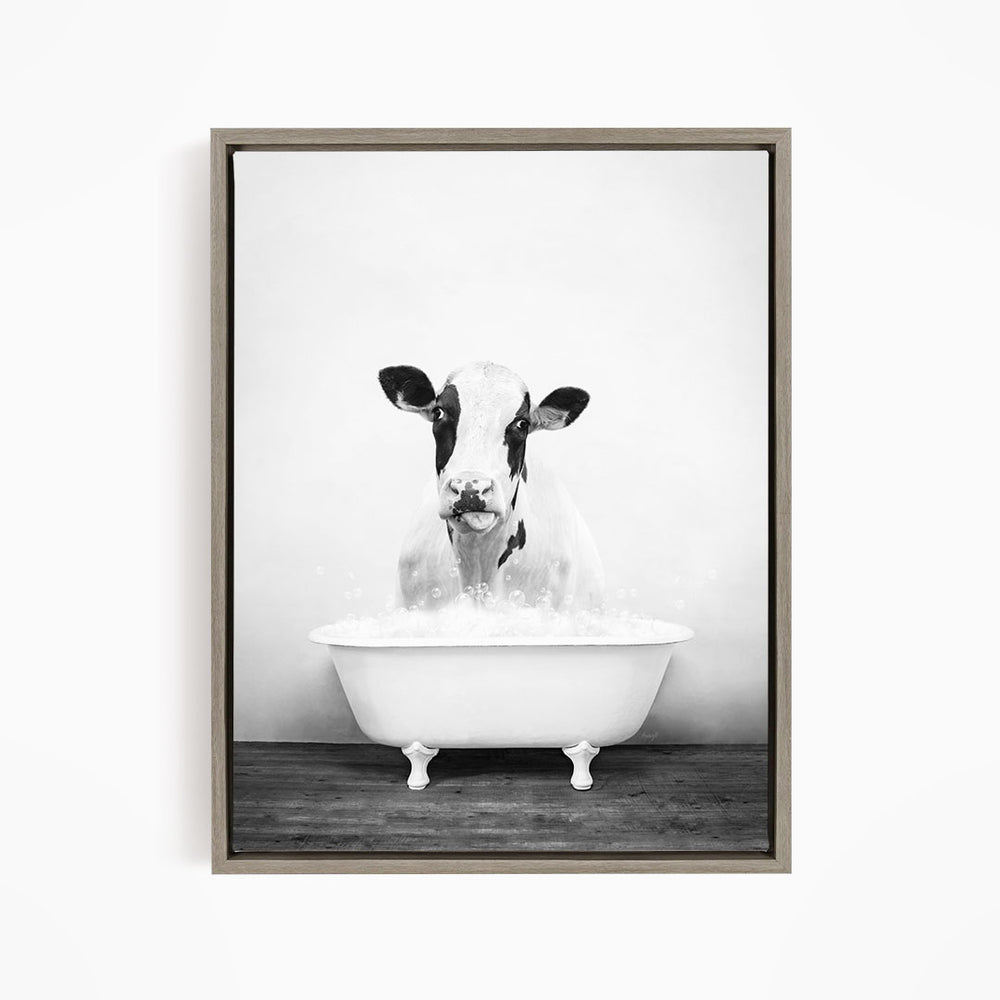 A black and white image of a cow standing in a bathtub filled with water, looking directly at the camera.