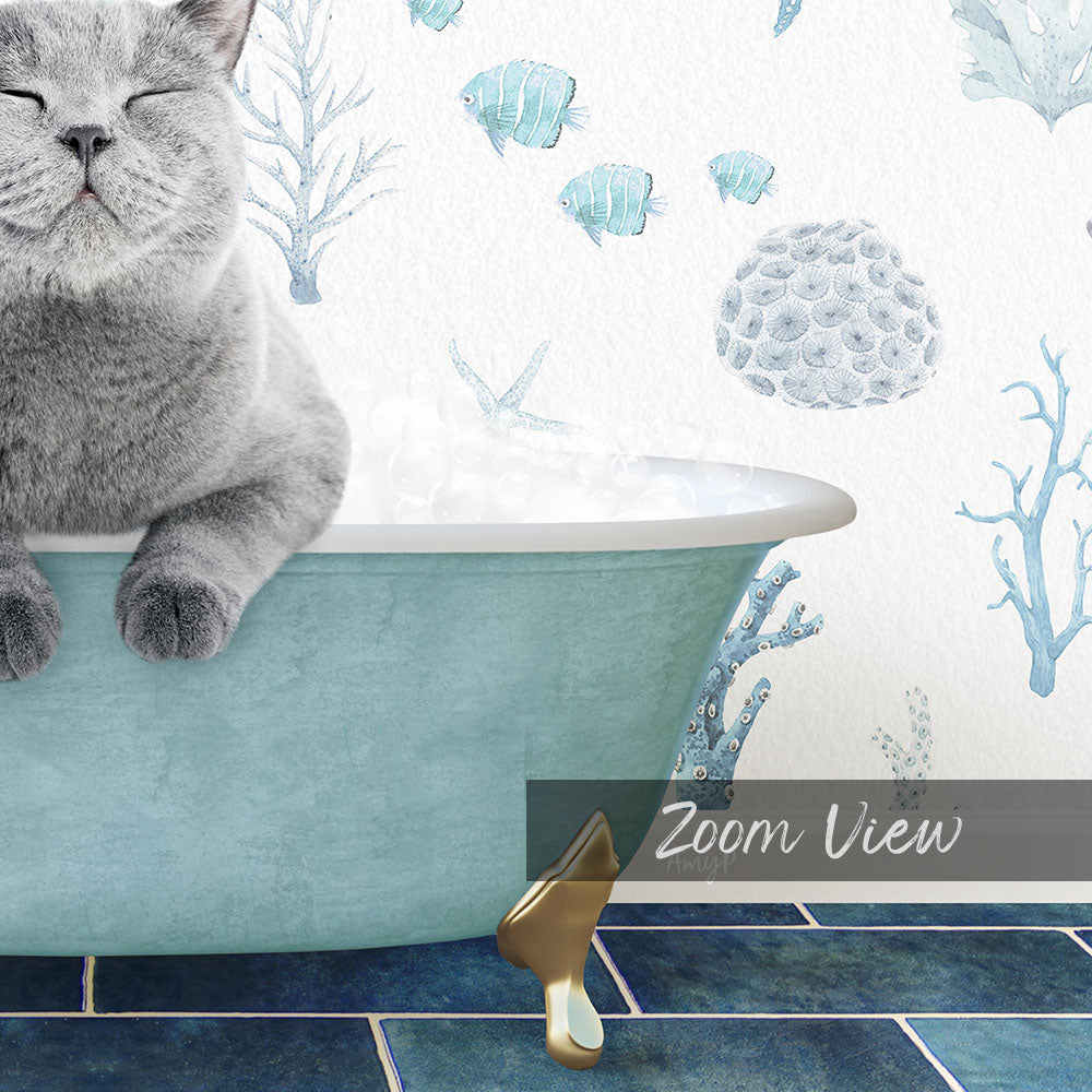 A gray cat sitting in a blue bathtub, surrounded by a wallpaper with fish and coral designs.