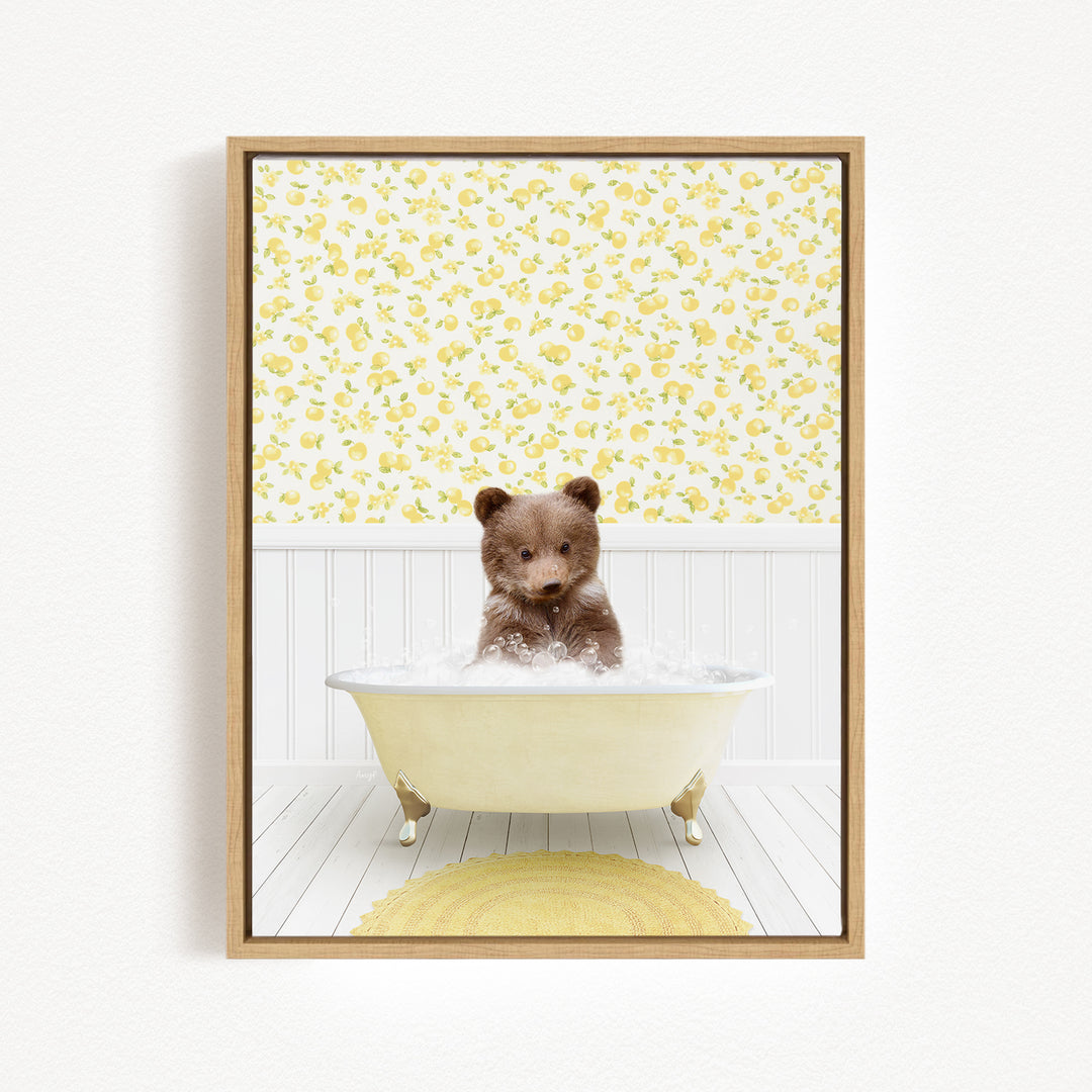 A brown bear sitting in a white bathtub filled with water, surrounded by a yellow floral pattern on the wall behind it.