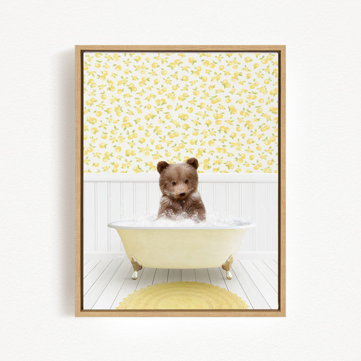 A brown bear sitting in a white bathtub filled with water, surrounded by a yellow floral pattern on the wall behind it.
