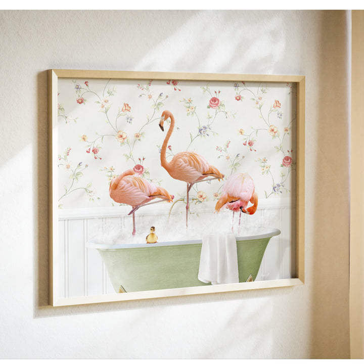 A framed print depicting three pink flamingos standing in a green bathtub filled with water, surrounded by a floral wallpaper.