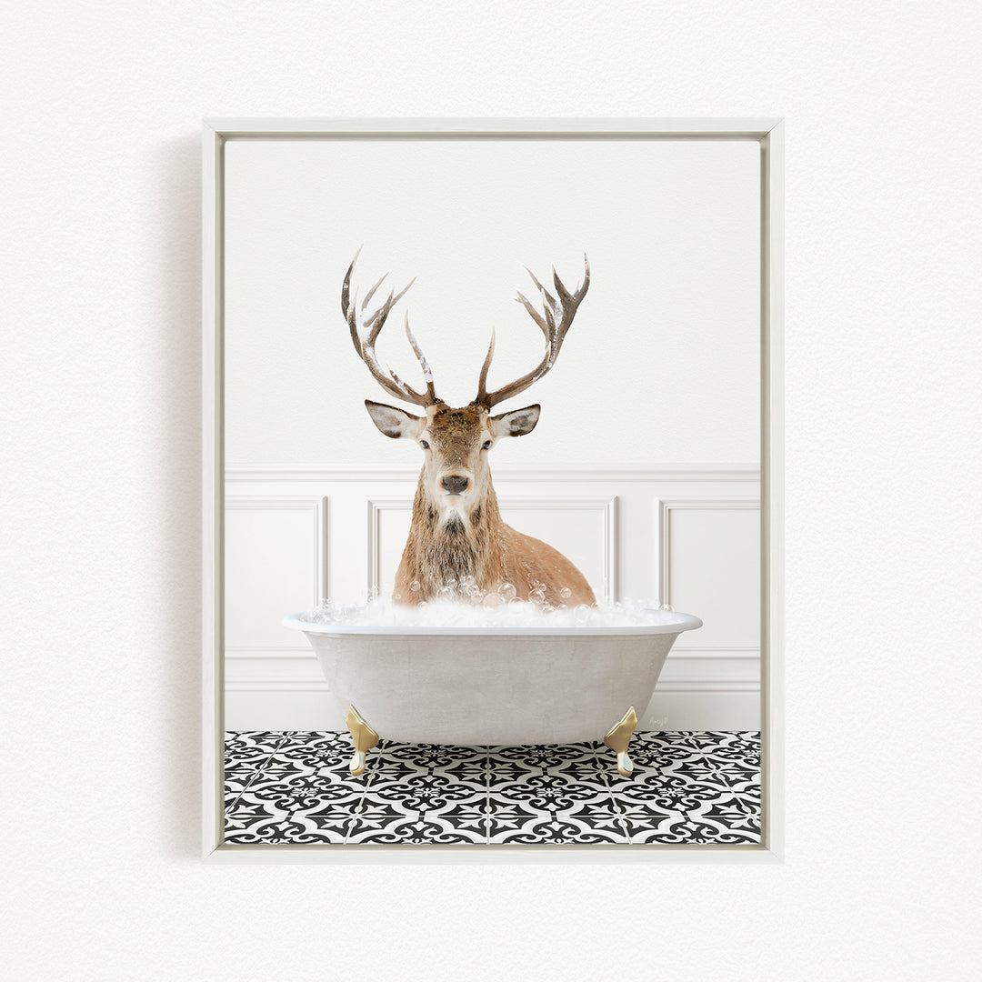 A deer with large antlers is sitting in a white bathtub filled with water, creating a whimsical and unexpected scene.
