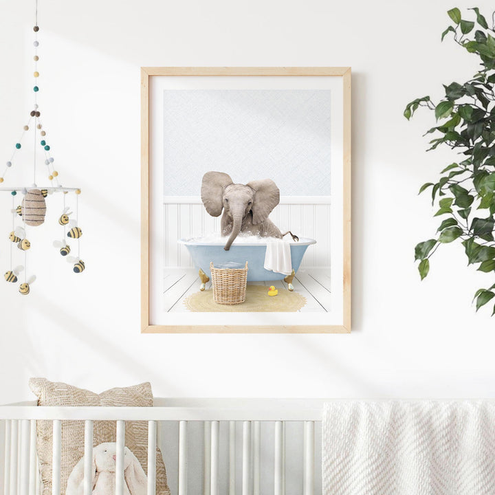 A framed image of an elephant sitting in a bathtub, surrounded by various decorative elements such as a hanging mobile, a plant, and a basket of toys.