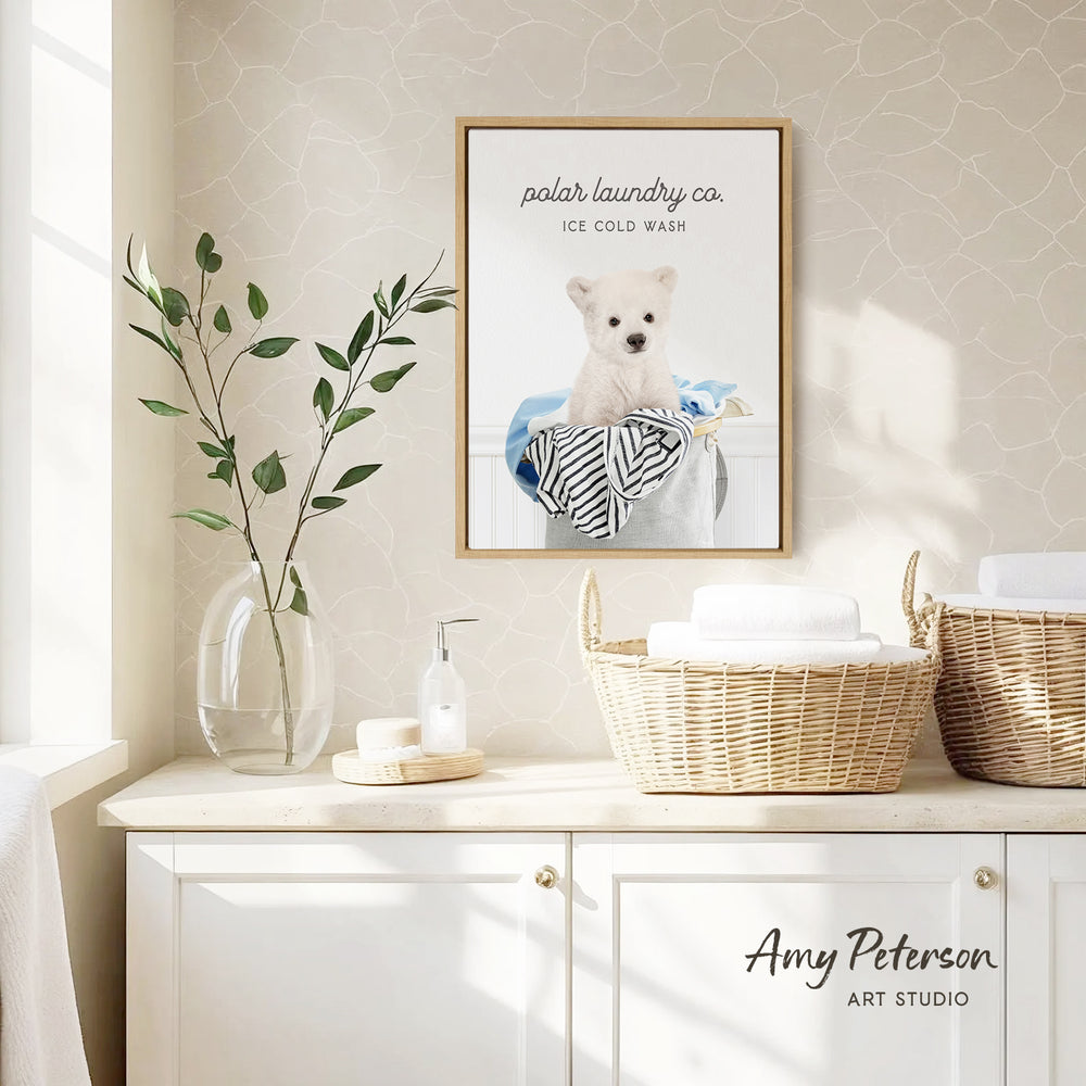 a framed poster of a polar bear sitting in a basket, hanging on a wall above a white cabinet with baskets.
