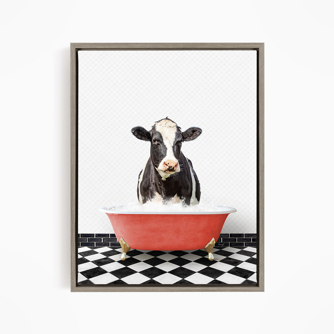 A black and white cow is standing in a red bathtub filled with water, creating a whimsical and humorous scene.