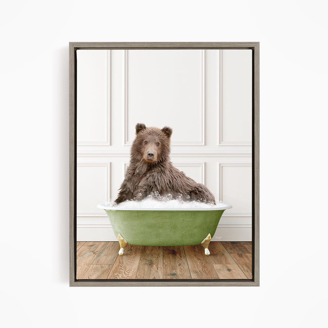 A brown bear sitting in a green bathtub filled with bubbles, looking directly at the camera.