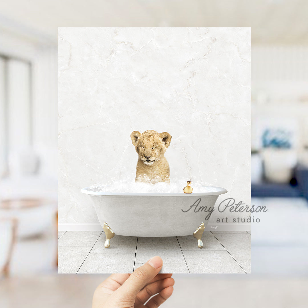 a hand holding up a photo of a lion cub in a bathtub