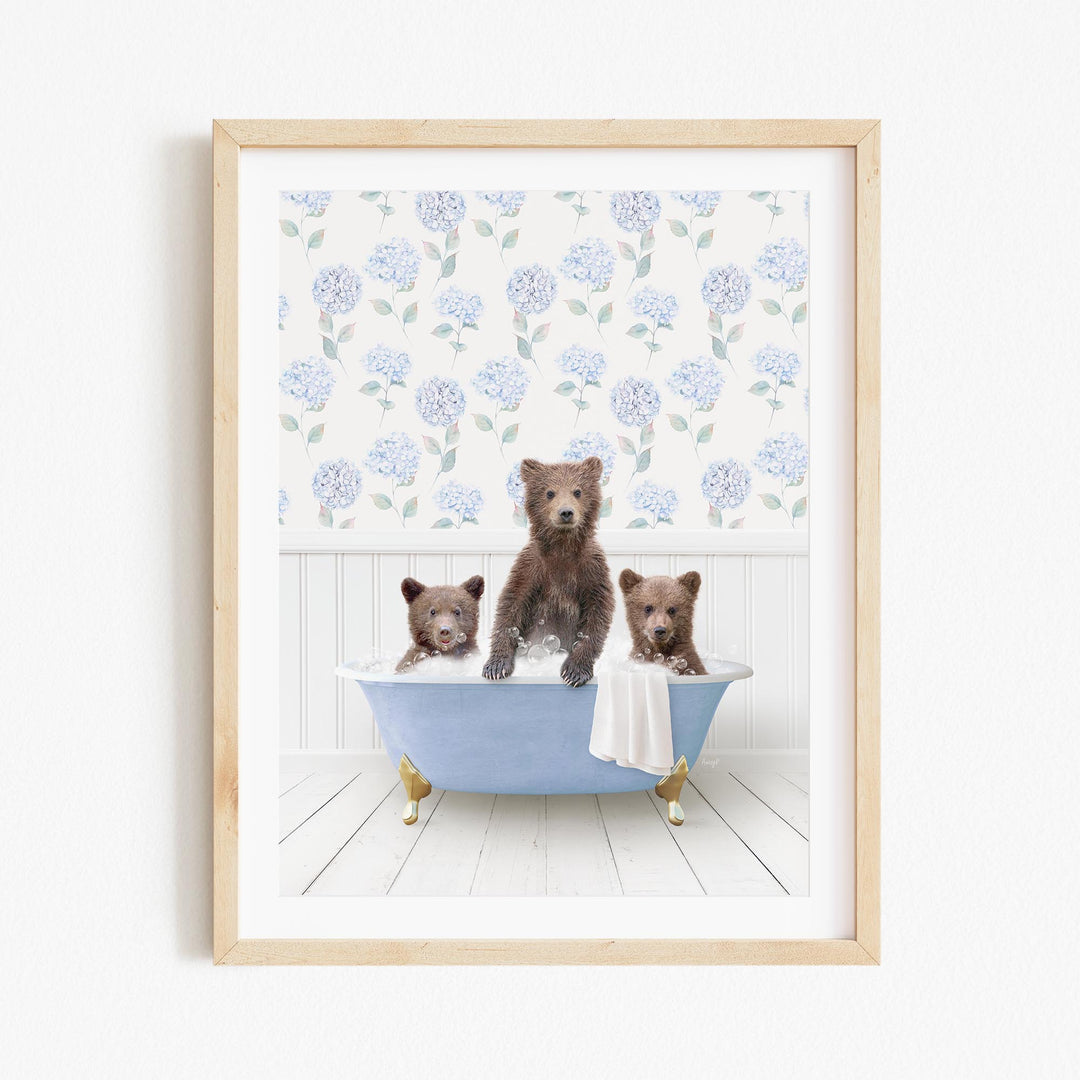A framed image depicting three bears sitting in a bathtub, with a floral pattern on the wall behind them.