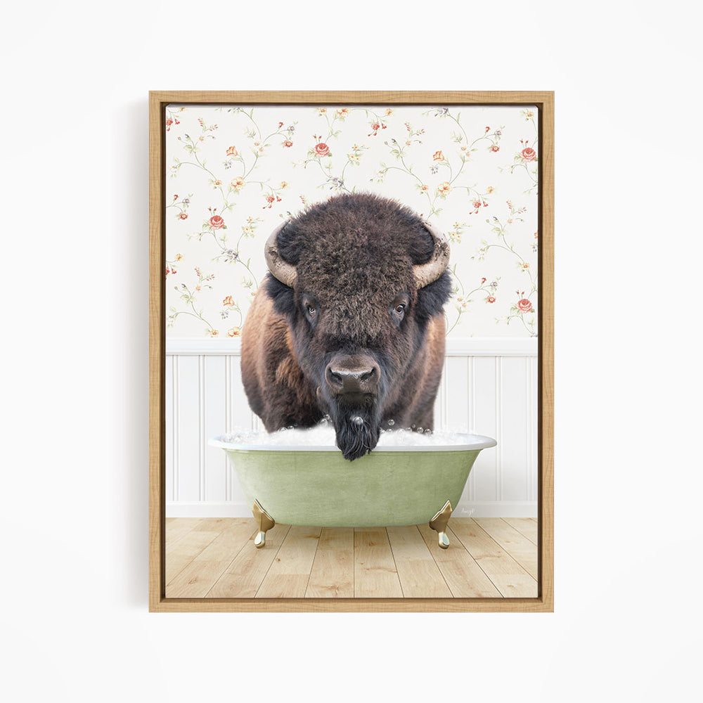 A buffalo with a long beard is sitting in a green bathtub, looking directly at the camera.