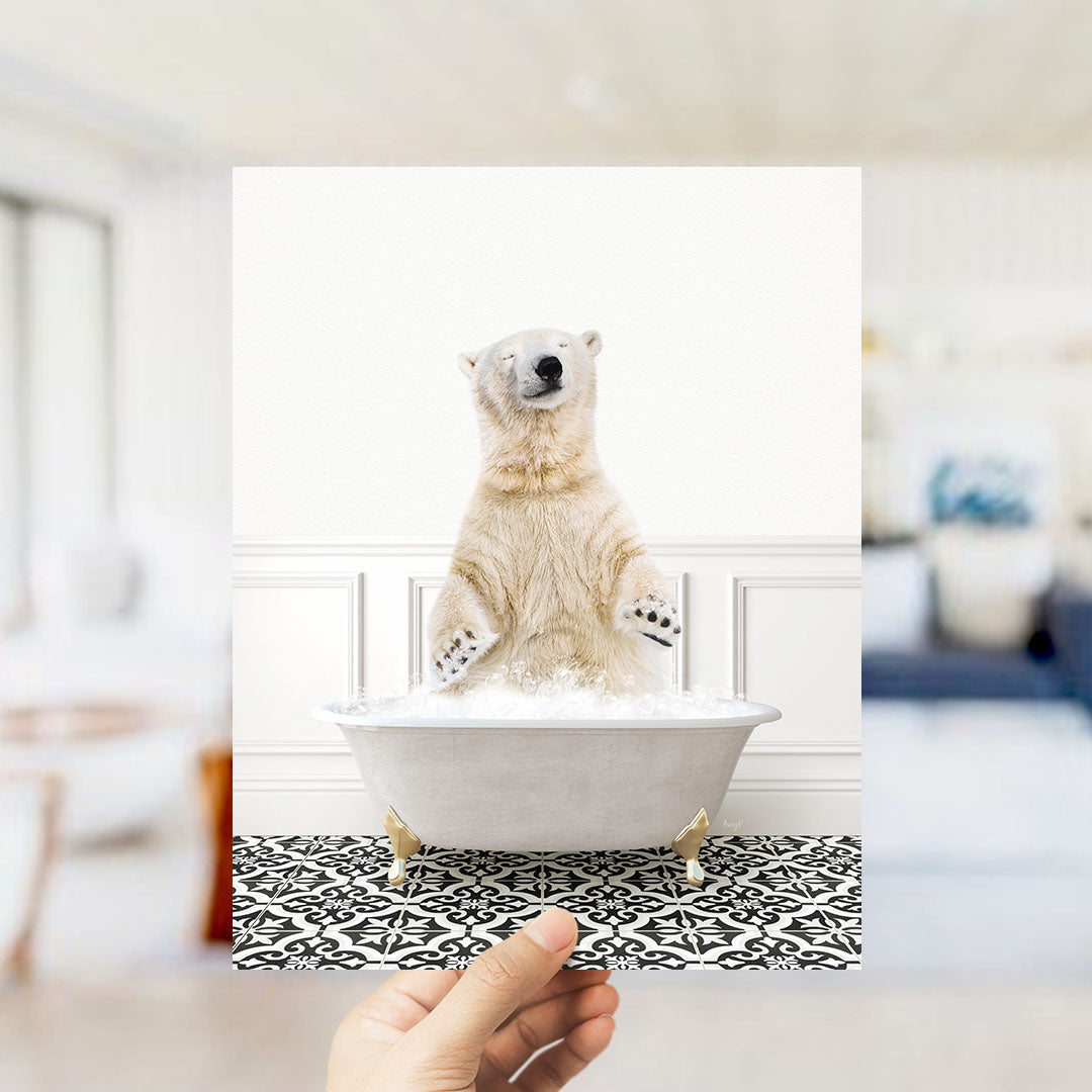 A polar bear sitting in a bathtub filled with bubbles, with a hand holding the image up to the camera.