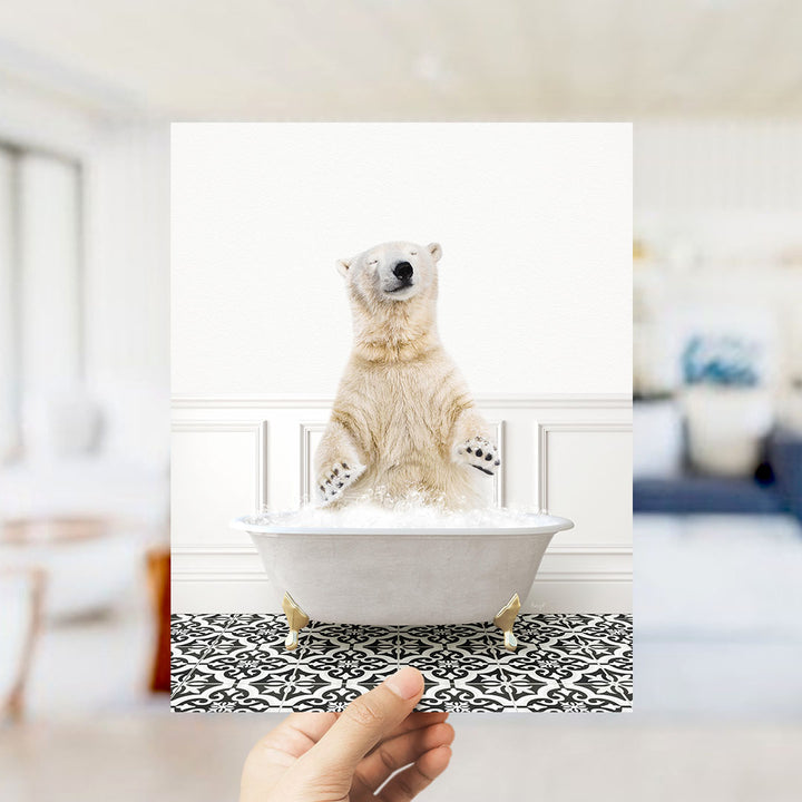 A polar bear sitting in a bathtub filled with bubbles, with a hand holding the image up to the camera.