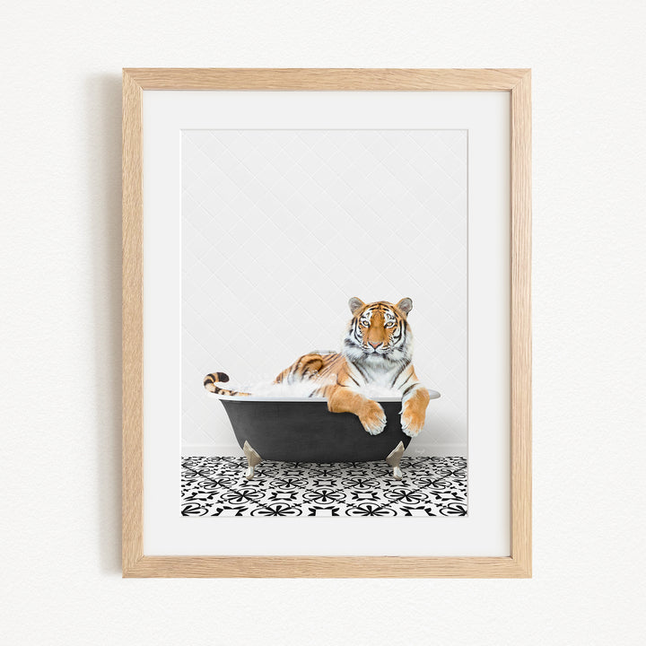 A tiger is sitting in a black bathtub, surrounded by a black and white patterned floor.