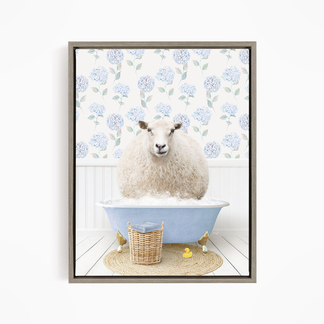 A fluffy white sheep sits in a blue bathtub filled with bubbles, surrounded by a wicker basket and yellow rubber ducks.