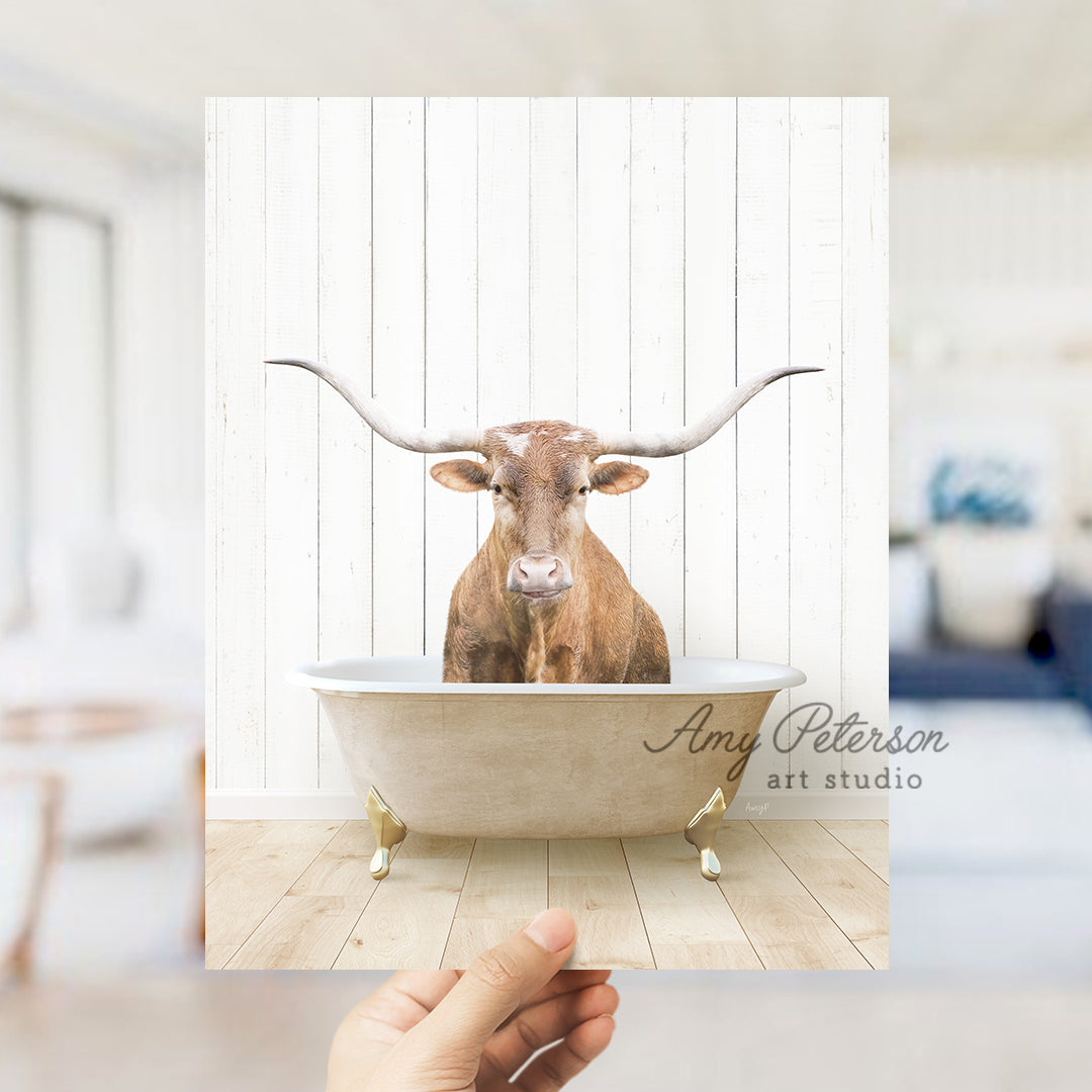 a cow is sitting in a bathtub with long horns