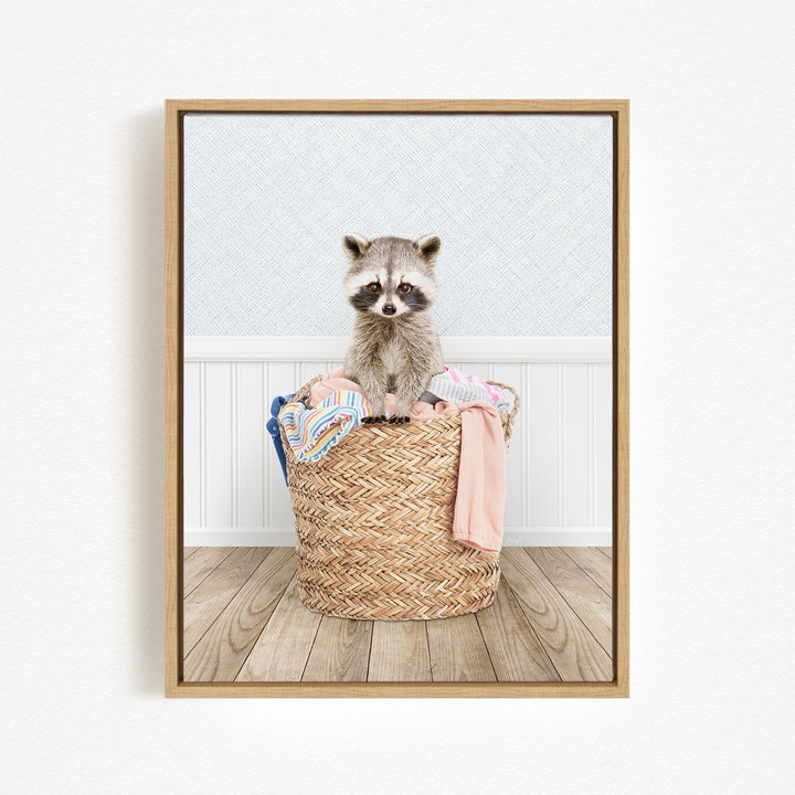 A raccoon sitting in a woven basket filled with clothes.