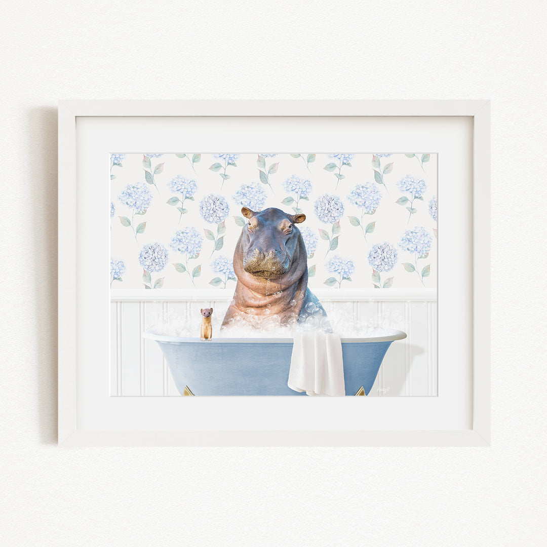A framed image depicting a hippopotamus sitting in a bathtub filled with water, surrounded by blue flowers.