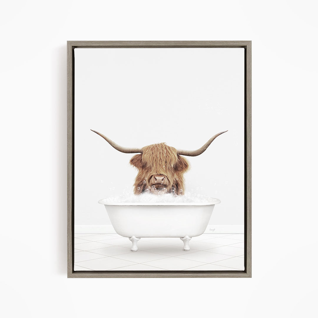 A Highland cow with long horns is sitting in a white bathtub filled with water, appearing to enjoy the bath.