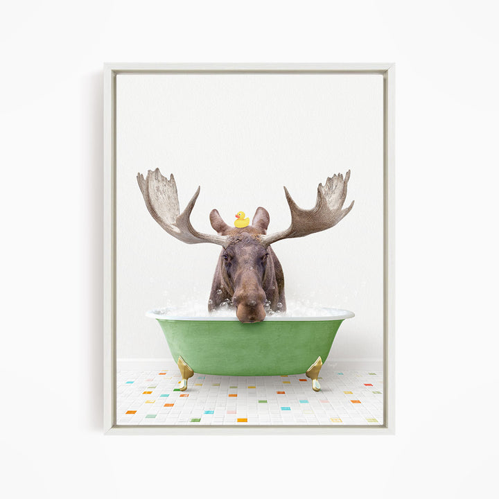 A moose with large antlers is sitting in a green bathtub, with a rubber duck floating on its head.