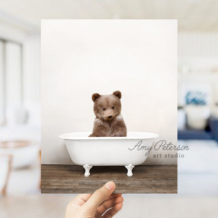 a small brown bear sitting in a bath tub