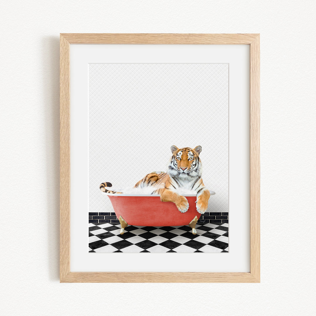 A tiger is sitting in a red bathtub on a black and white checkered floor.