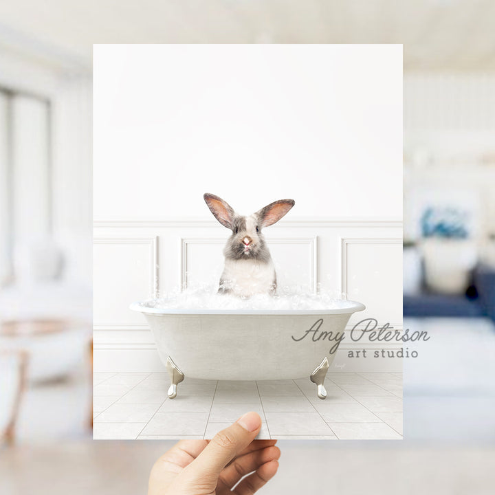 a person holding up a photo of a rabbit in a bathtub