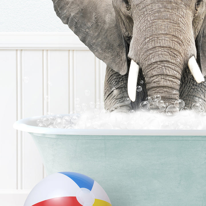 an elephant in a bathtub with bubbles and a beach ball