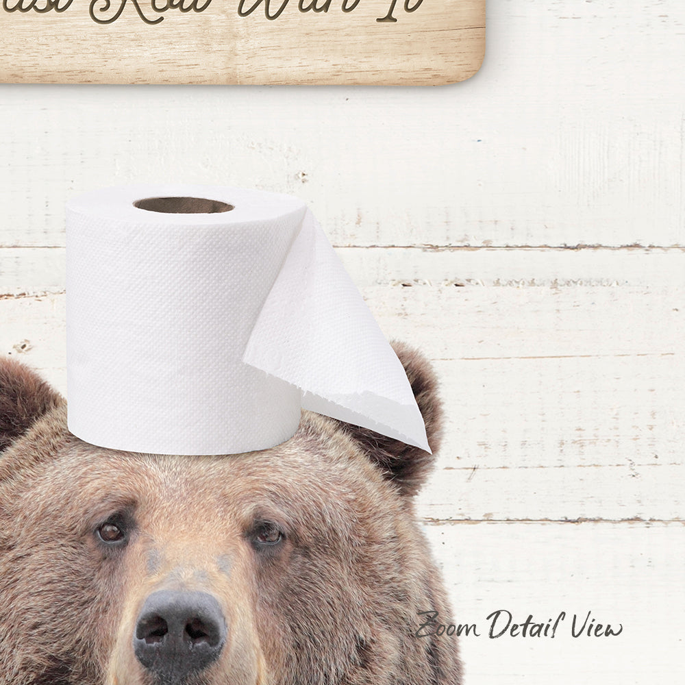 A brown bear wearing a roll of toilet paper on its head, with a wooden sign above it that says "Wanted".