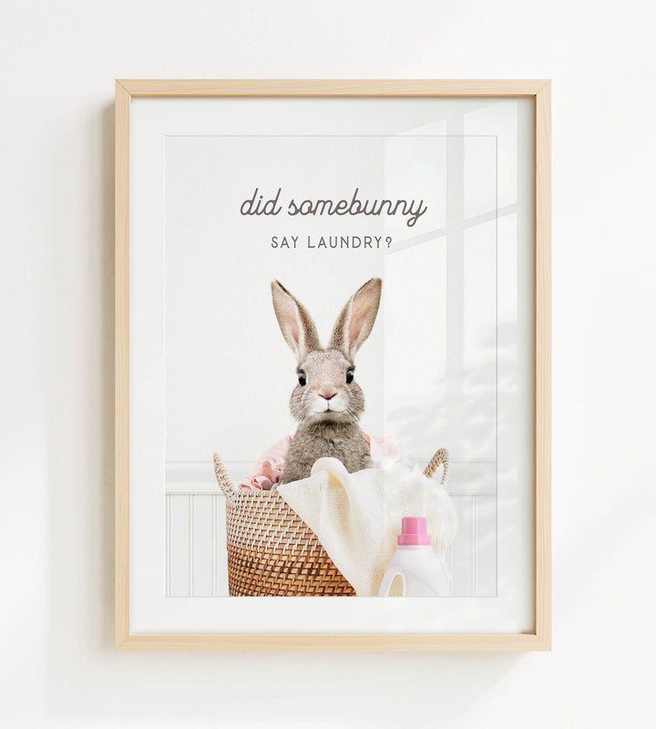 A framed image of a rabbit sitting in a basket filled with laundry, with the text "did some bunny say laundry?" displayed above the rabbit.