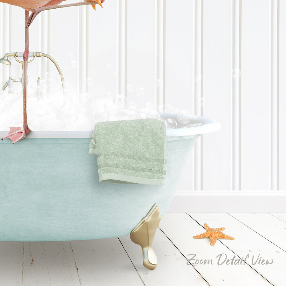 A light blue clawfoot bathtub filled with bubbles, with a green towel hanging on the side and a starfish on the floor.
