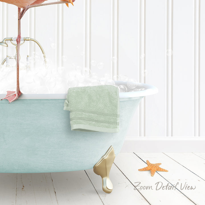 A light blue clawfoot bathtub filled with bubbles, with a green towel hanging on the side and a starfish on the floor.