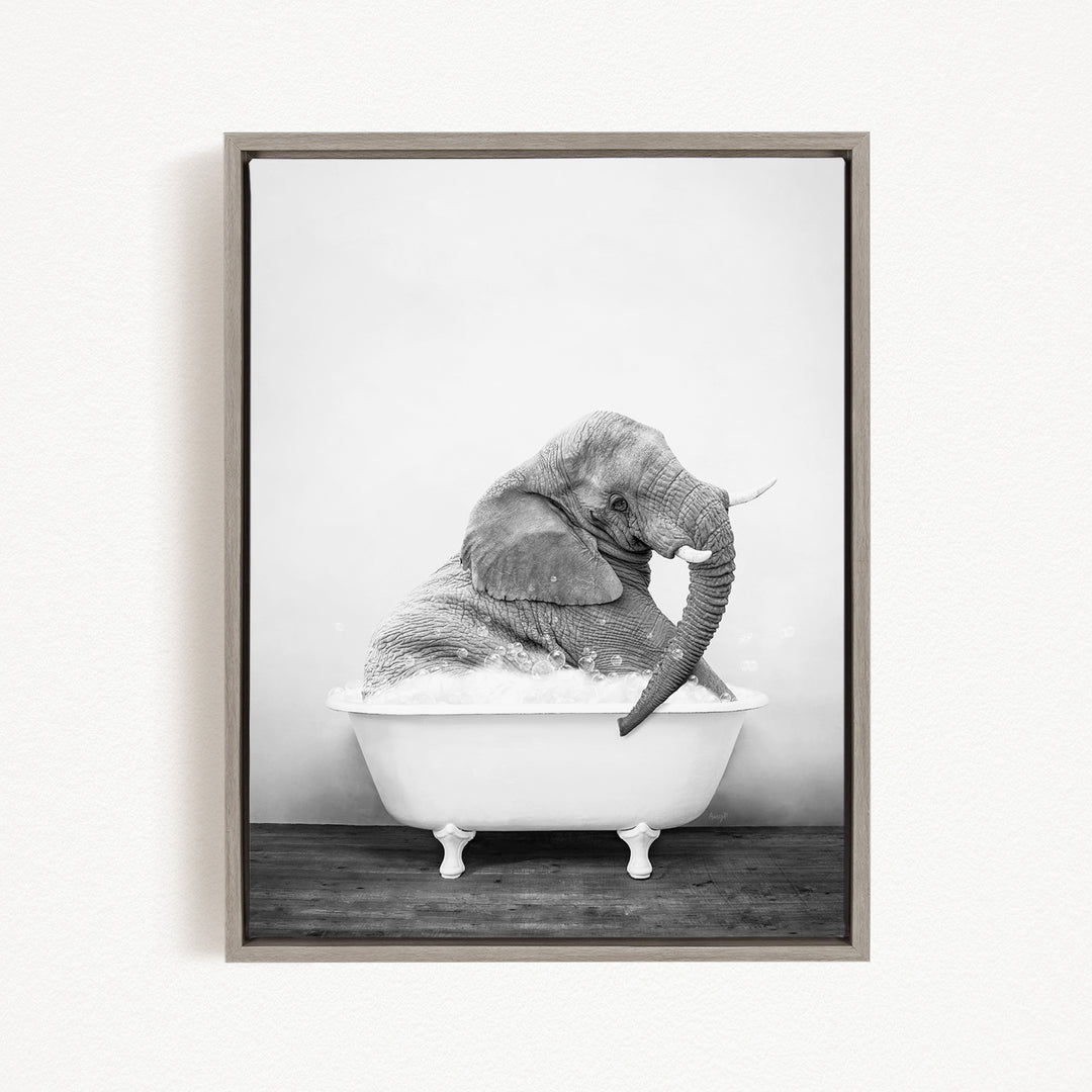 A black and white photograph of an elephant sitting in a bathtub filled with water.