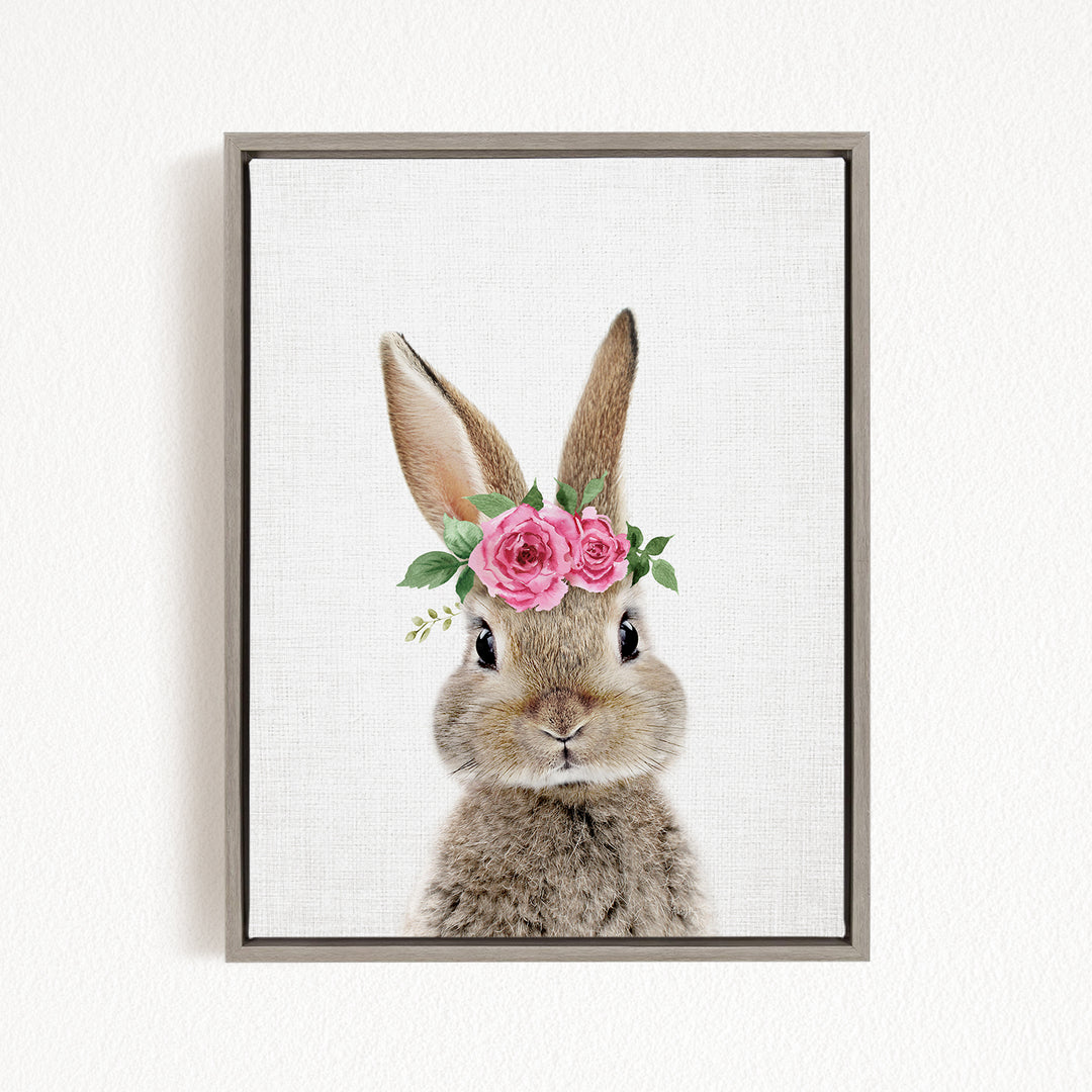 A cute bunny wearing a floral crown of pink roses and greenery.