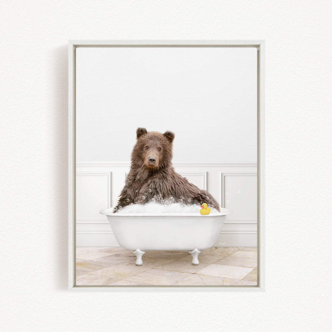 A brown bear sitting in a white bathtub, with a rubber duck floating in the water.