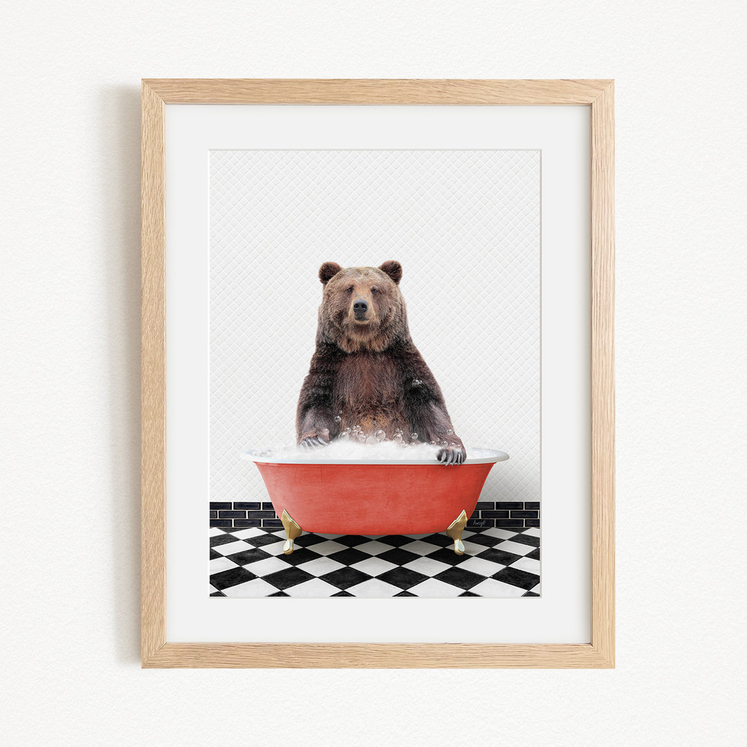A brown bear sitting in a red bathtub on a black and white checkered floor.