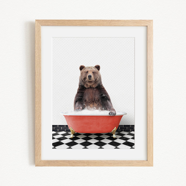 A brown bear sitting in a red bathtub on a black and white checkered floor.