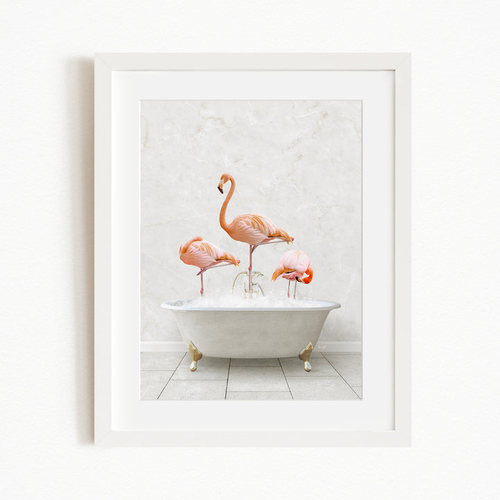 A framed image depicting three flamingos standing in a white bathtub filled with water.