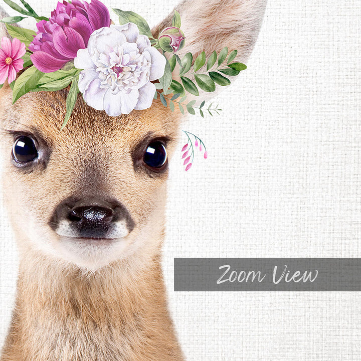 A close-up portrait of a deer with a floral crown on its head, set against a white background.