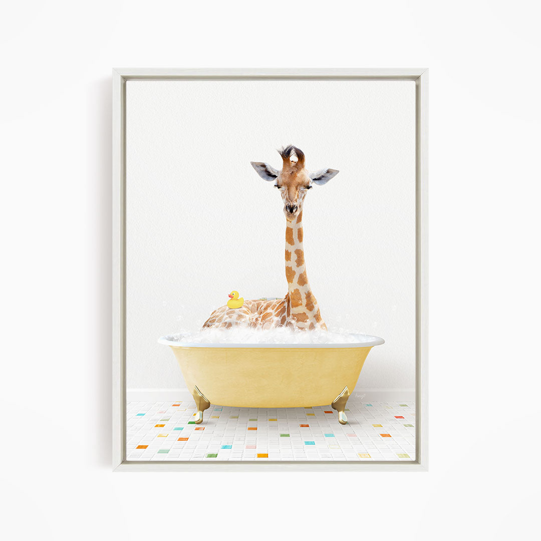 A giraffe is sitting in a yellow bathtub filled with bubbles, with a rubber duck floating nearby.