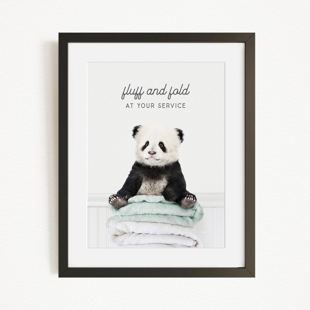 A panda bear sitting on a stack of towels, with the text "fluff and fold at your service" written above the image.