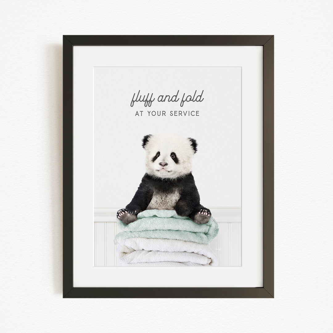 A panda bear sitting on a stack of towels, with the text "fluff and fold at your service" written above the image.
