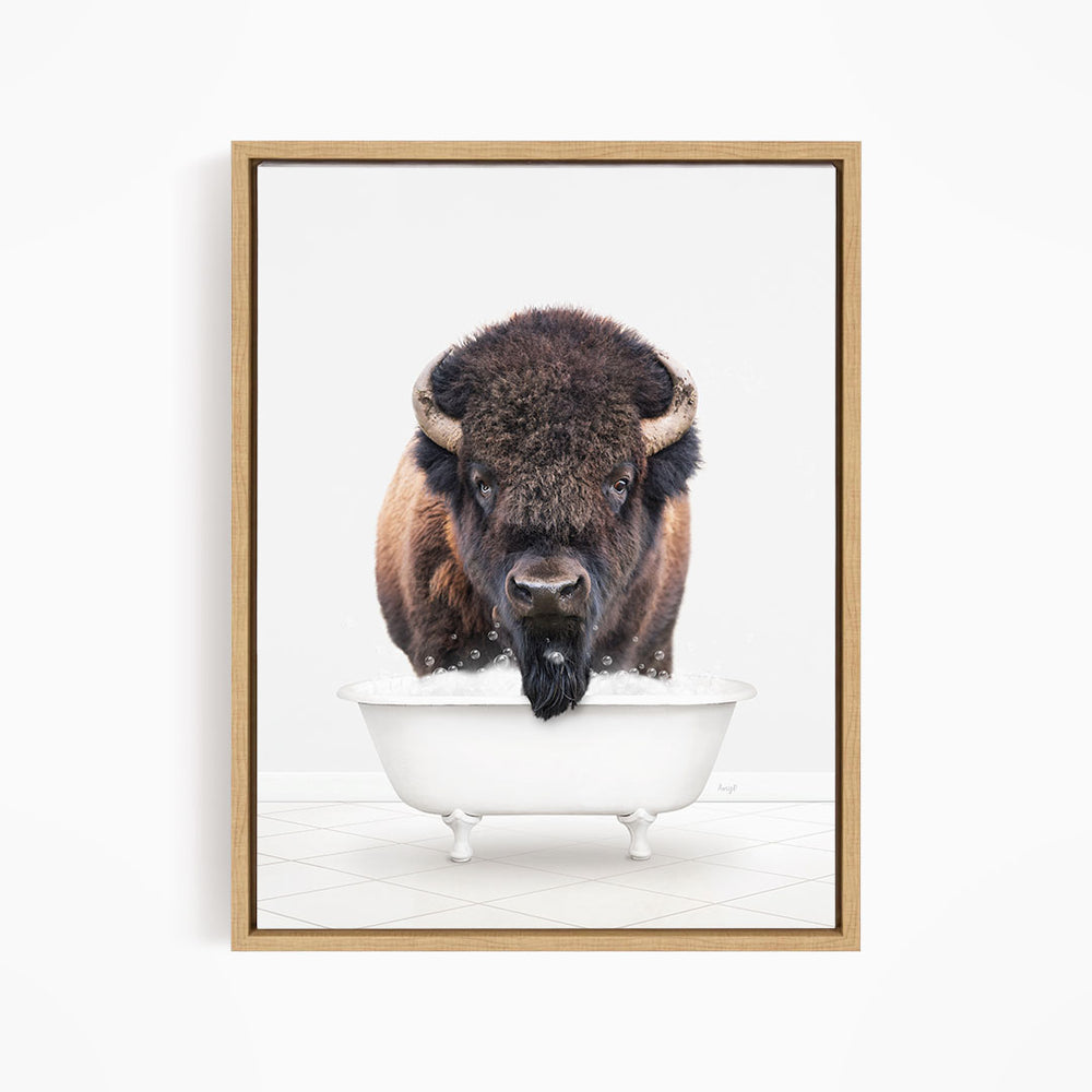 A buffalo with a black mane and horns is standing in a white bathtub, with its head poking out of the tub.